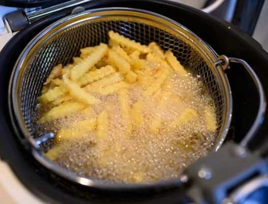 Bir mutfak tezgahında farklı türde yağlarla dolu beş cam şişe yer alıyor.