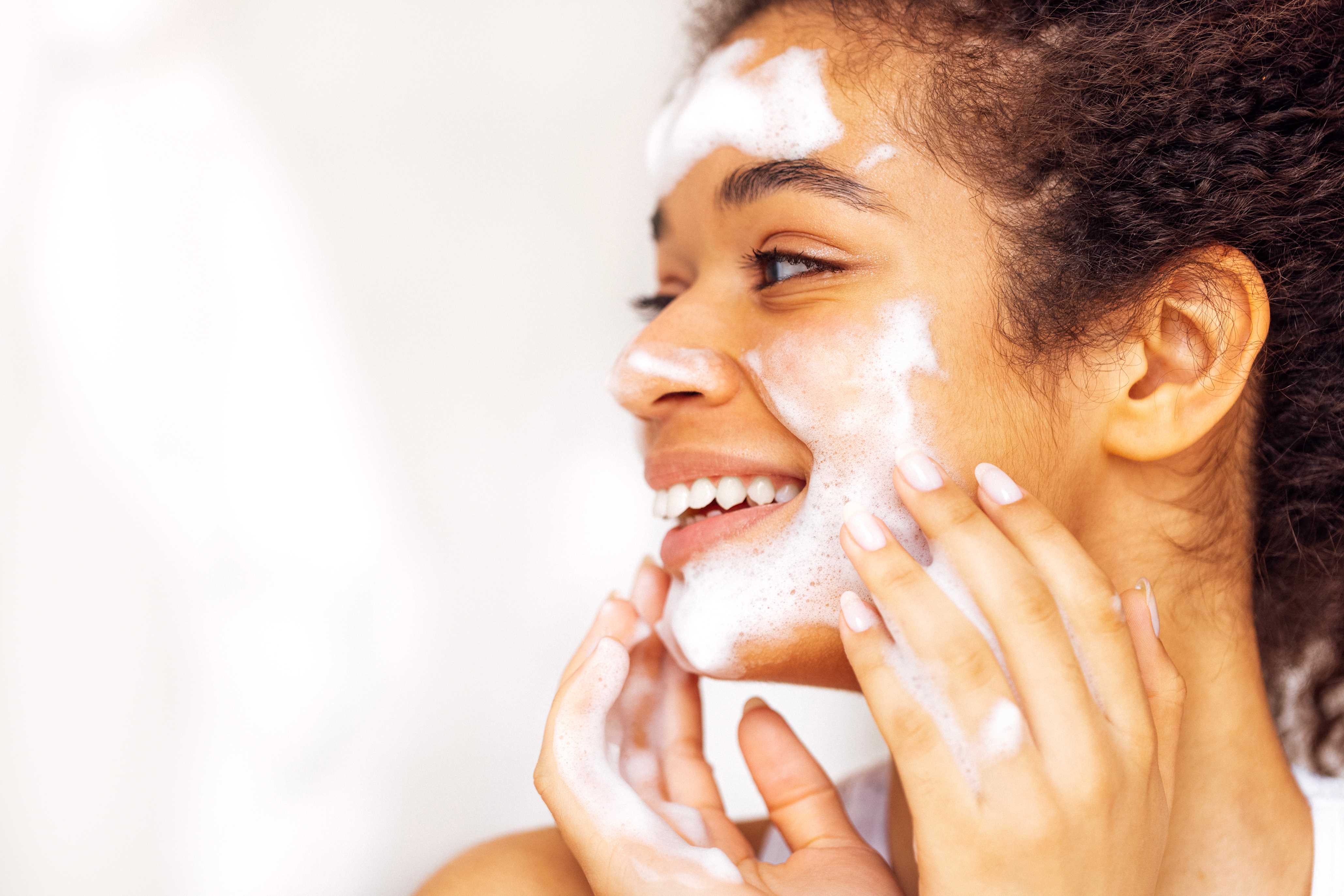 Close-up de jovem membro do painel de testes clínicos testando lavagem facial