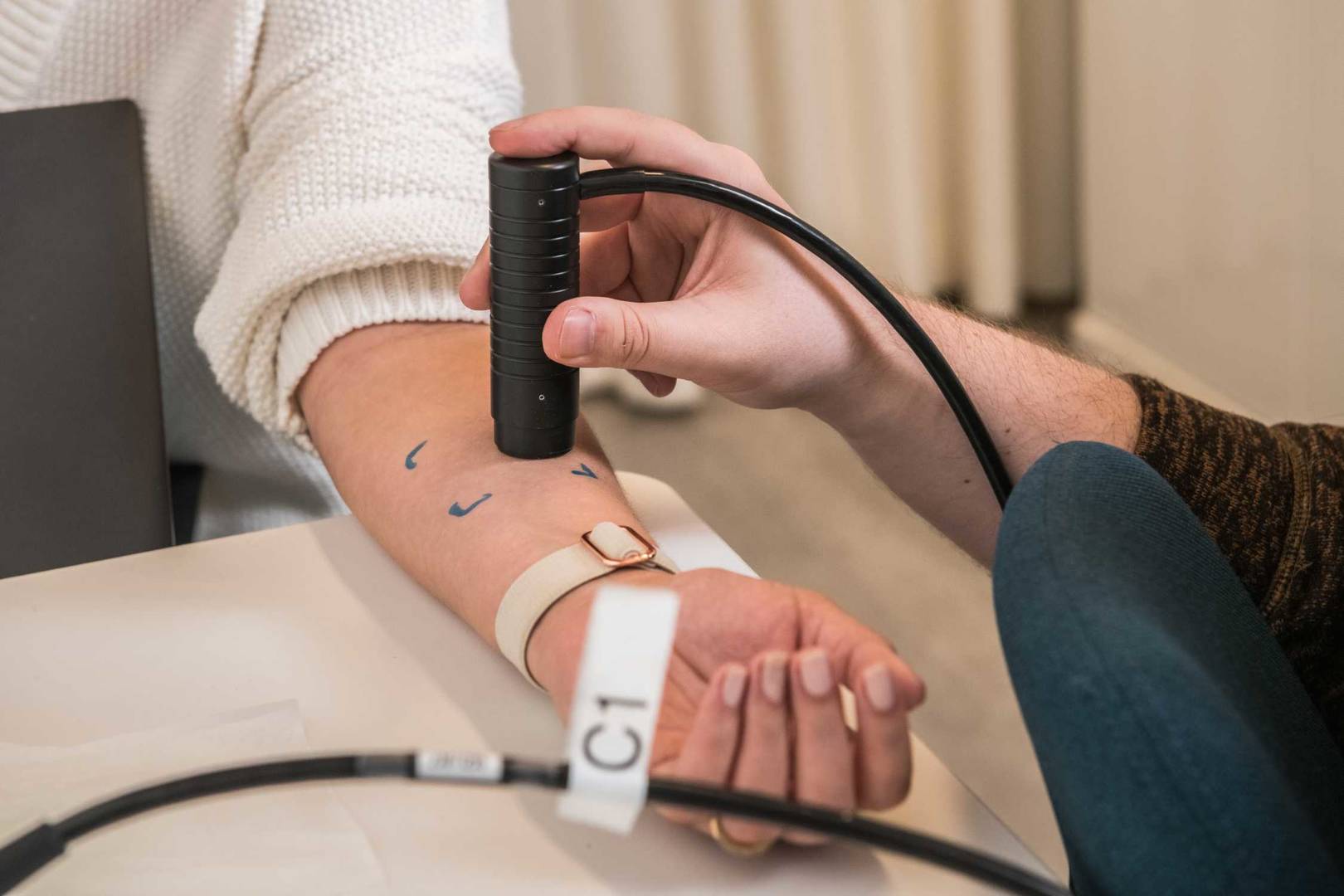 Clinical testing panelist being tested on arm by a machine