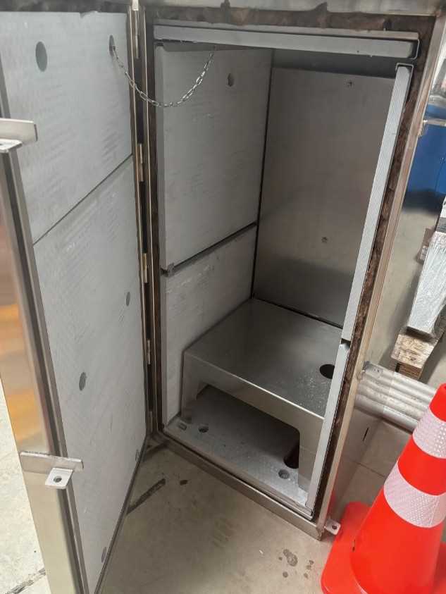 Industrial stainless steel control cabinet in workshop.