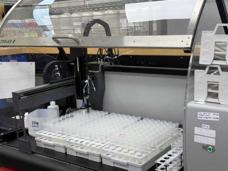 Automated laboratory analyzer processing rows of sample tubes in a lab