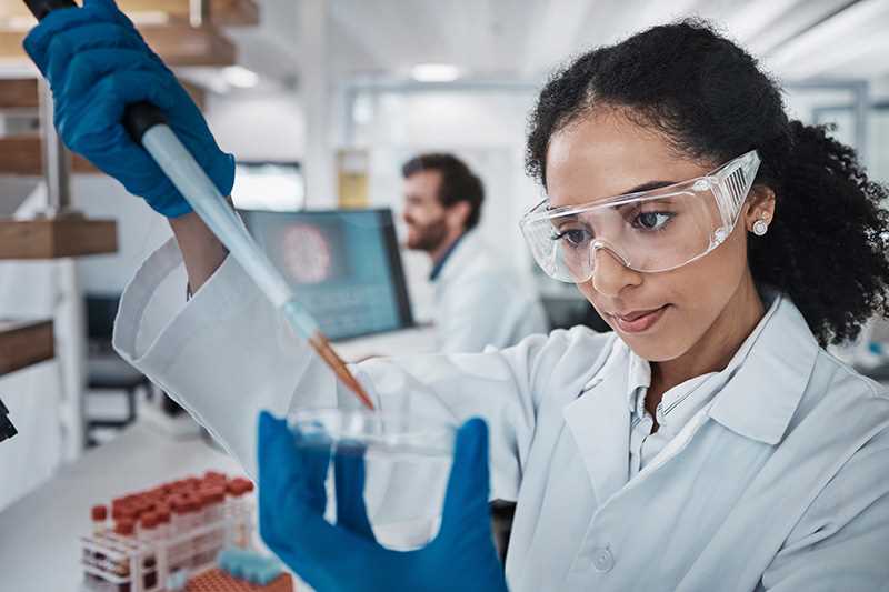 Scientist using pipette in laboratory