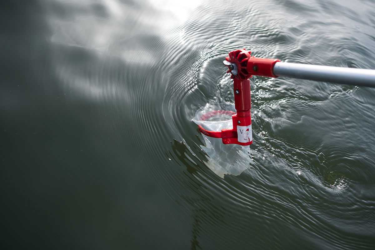 Dispositivo de amostragem recolhendo água na superfície de uma barragem.